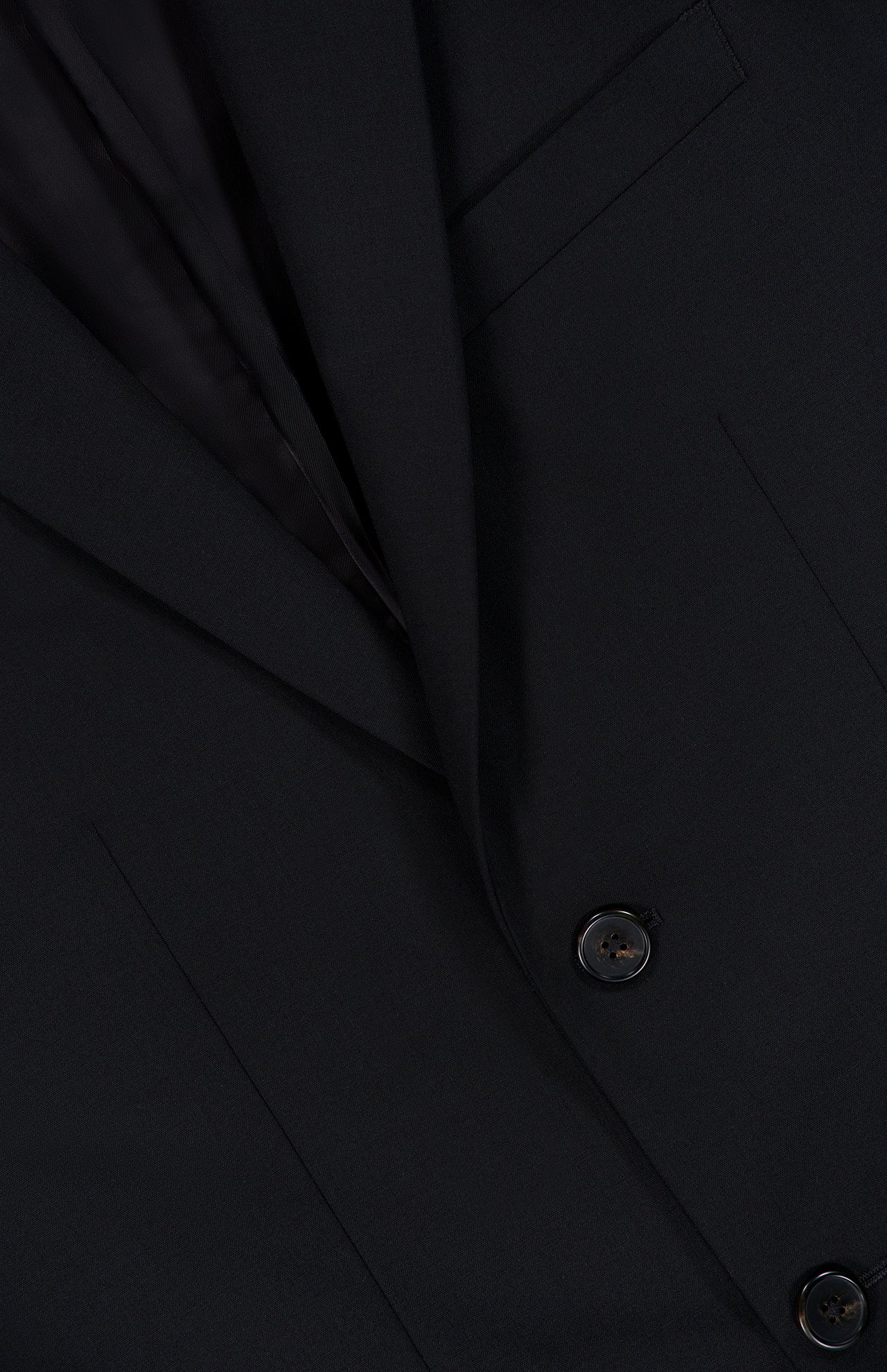 Close-up of the THEORY Chambers Blazer in Stretch Wool, shown in black, highlighting two buttons, a portion of the lapel, and a breast pocket.