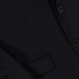Close-up of the THEORY Chambers Blazer in Stretch Wool, featuring black buttons on the sleeve, a flap-front pocket, and meticulously stitched seams. The smooth virgin wool fabric is finely tailored for a polished finish.