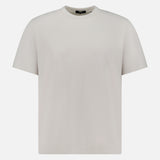 The THEORY Delroy Cotton-blend T-Shirt is a plain, stone-colored short-sleeve tee displayed on a white background. Shown from the front, it features a classic round neckline and has no visible logos or designs. Made from a soft cotton-blend fabric, this comfortable t-shirt is perfect for everyday wear.