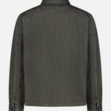 Back view of the THEORY Denim Snap-front Overshirt in dark gray stretch-cotton denim, featuring long sleeves, buttoned cuffs, and a straight hem, displayed on a plain white background.