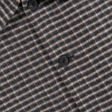 Close-up of the Double Face Wool Short Jacket by THEORY, a men’s outerwear piece in dark brown featuring a classic wool check pattern in brown and gray tones, finished with black buttons and a visible black THEORY label on the collar.