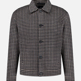 The THEORY Double Face Wool Short Jacket is a men’s outerwear piece with long sleeves, a button-up front, and a collared neckline. Crafted in dark brown with a classic wool check pattern in brown, black, and white, this jacket features a straight hem and offers a simple, timeless design.