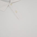 A close-up of the Goris Long Sleeve Polo Shirt by THEORY shows its white collared design with two buttons and a visible THEORY label at the neckline.