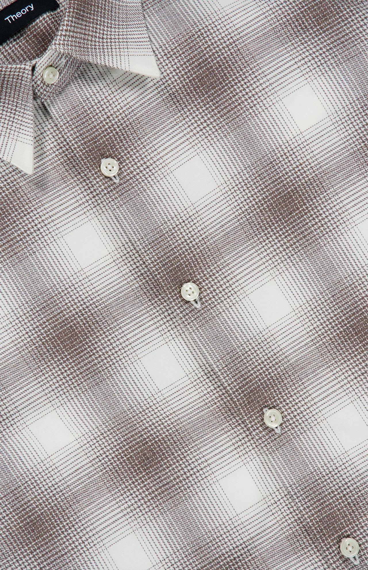 Close-up of the THEORY Irving Faded Plaid Shirt, featuring a gray and white checkered pattern. The shirt includes white buttons, a visible collar, and subtly textured grid detailing in the fabric.