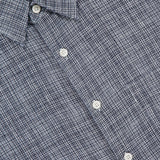 Close-up of the THEORY Irving Short Sleeve Relaxed Shirt in blue and white plaid, featuring a relaxed fit, collar, white buttons, and a textured woven fabric. The THEORY label is visible.