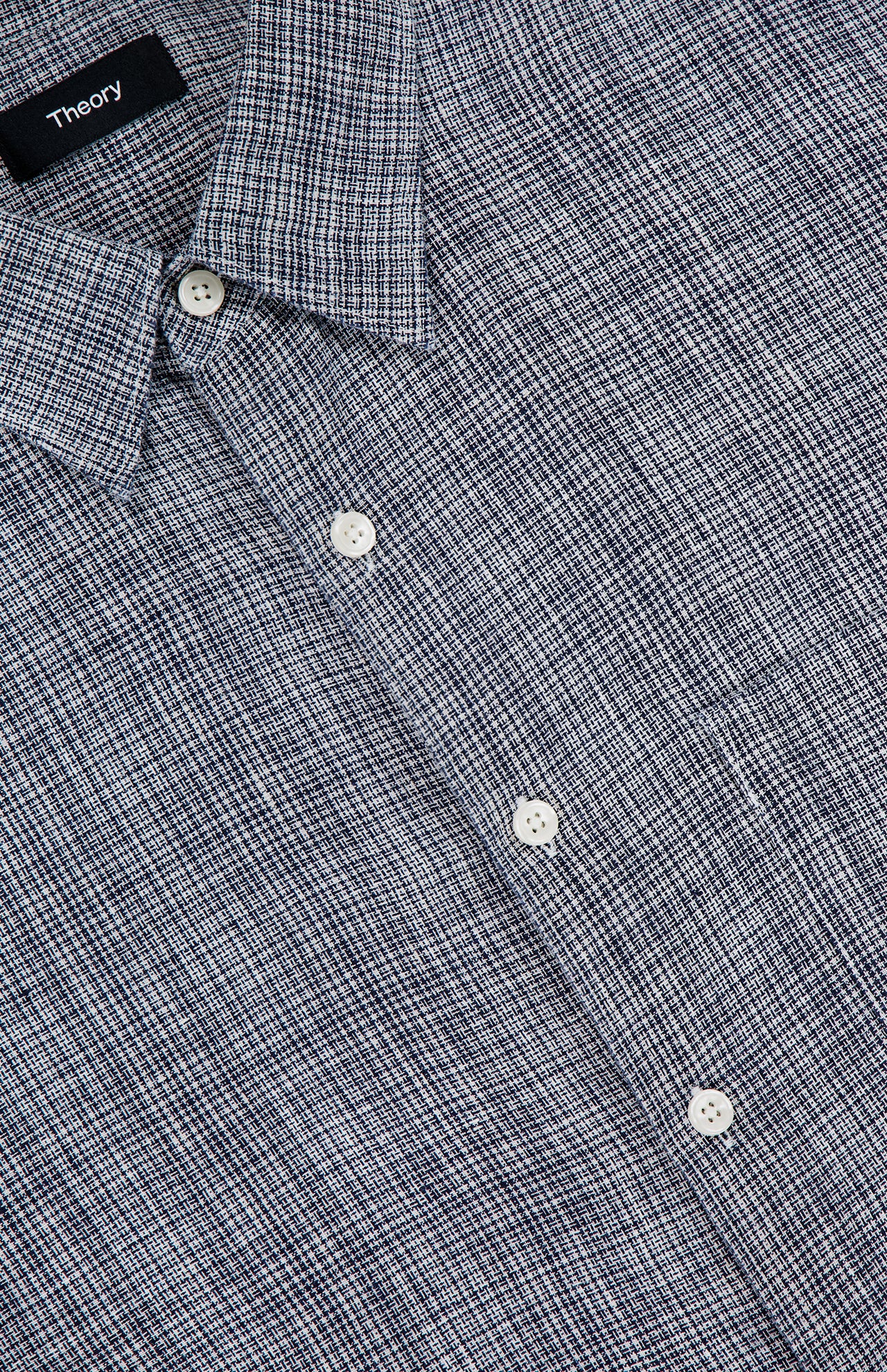 Close-up of the THEORY Irving Short Sleeve Relaxed Shirt in blue and white plaid, featuring a relaxed fit, collar, white buttons, and a textured woven fabric. The THEORY label is visible.