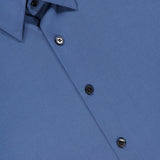 Close-up of the THEORY Irving Short Sleeve Structure Shirt in cornflower blue, folded neatly. Features black buttons, visible collar and front, and an inner brand tag—ideal for a polished, wrinkle-free look.