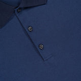 Close-up of the Jacquard Geo Polo Shirt by THEORY, a textured cotton navy blue slim fit polo featuring a subtle geometric pattern, dark collar, two black buttons, and "THEORY" partially visible on the collar tag.