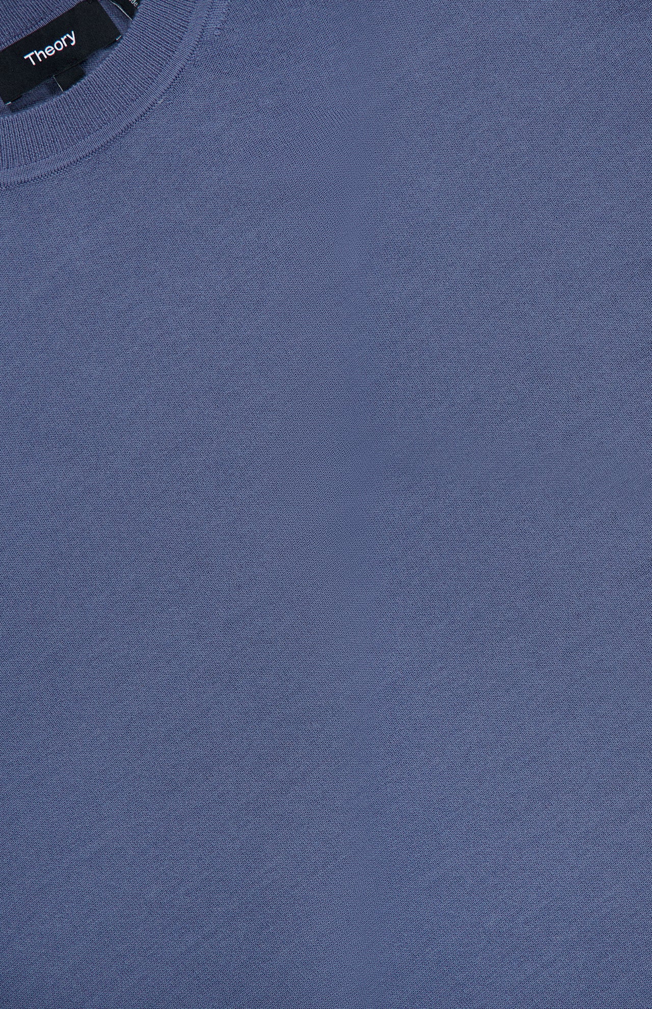 A close-up of the Regal Crew Neck Sweater in dusty blue, featuring a visible THEORY brand label near the collar.