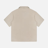 The THEORY Soft Terry Short Sleeve Shirt is shown from the back in beige, featuring a plain design with no visible patterns or logos—a versatile collared option for any casual work wardrobe.