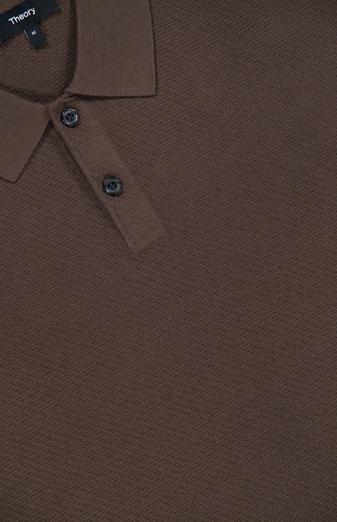 Close-up of the Soris Short Sleeve Polo Shirt in brown, featuring a textured knit fabric, a collar, and two buttons. The THEORY brand label is visible near the neckline, emphasizing this men’s transitional piece that seamlessly combines versatility and style.