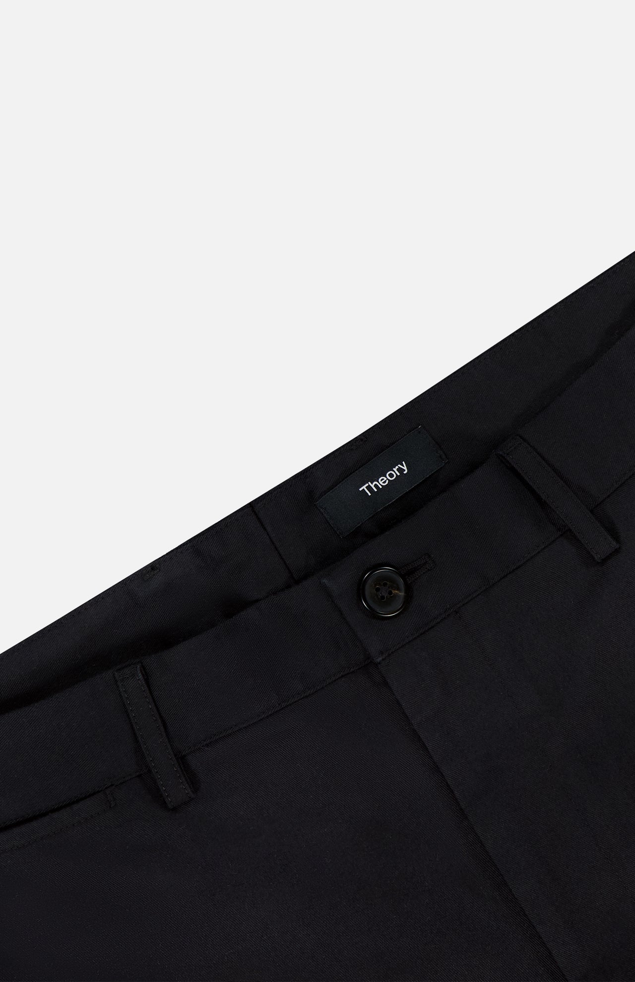 Close-up of the waistband and button on black Standard Chino Moons Shorts by THEORY. Made from smooth cotton twill, these men’s shorts feature belt loops and a tailored, polished look.
