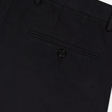 Close-up of the back of THEORY Standard Chino Moons Shorts, showing a single buttoned welt pocket, belt loops, and part of the waistband in black cotton twill against a light background.