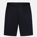The THEORY Standard Chino Moons Shorts are tailored men’s shorts in plain black cotton twill with button and zip closure, belt loops, and side pockets, shown against a white background.