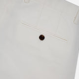 Close-up of the back pocket of THEORY's Standard Chino Moons Shorts, featuring white cotton twill fabric, a single brown button, and belt loops at the waistband.