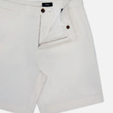 THEORY's Standard Chino Moons Shorts feature white cotton twill, a front zipper and button closure, belt loops, side pockets, and a partially unzipped design showing the interior waistband detail.