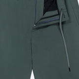 Close-up of THEORY Standard Nylon Drawstring Trouser Pants in dark green, featuring a relaxed fit, zip fly, button closure, elasticized waist with visible drawstring, and a subtle interior THEORY label for a modern look.