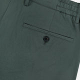 Close-up of the waist and back pocket of THEORY Standard Nylon Drawstring Trouser Pants in dark green, featuring an elasticized waist with belt loops and a single back pocket secured by a black button.