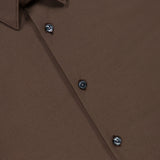 A close-up of the Sylvain Structure Dress Shirt by THEORY, a wrinkle-resistant chocolate brown dress shirt featuring a collar and black buttons, displayed on a flat surface.