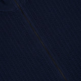 Close-up of the Walton Full Zip Sweater in navy blue, featuring a textured knit, visible full-length zipper, and ribbed mock collar, with the THEORY brand label displayed at the neckline.