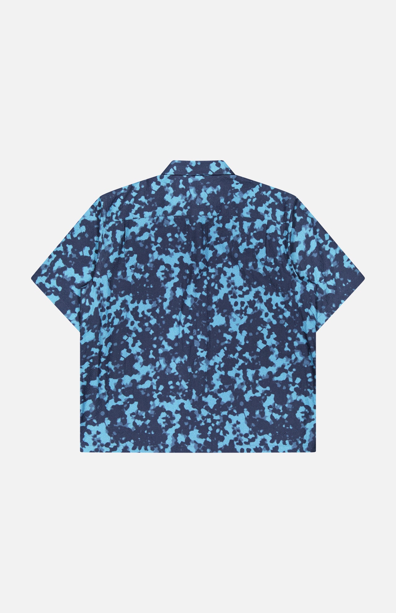 The THEORY Weekend Short Sleeve Shirt features a boxy fit, pointed collar, and blue/navy abstract camo print on a cotton blend. Displayed flat on a white background.