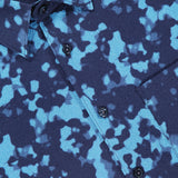 Close-up of the THEORY Weekend Short Sleeve Shirt, featuring a blue and black abstract splash pattern, black buttons, a chest pocket, and a cotton-blend fabric.