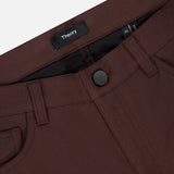 Close-up of the waistband and front pocket of Raffi Stretch Twill Pants by THEORY in slim fit dark brown, featuring a black button, belt loops, and an inner waistband label with the brand name.