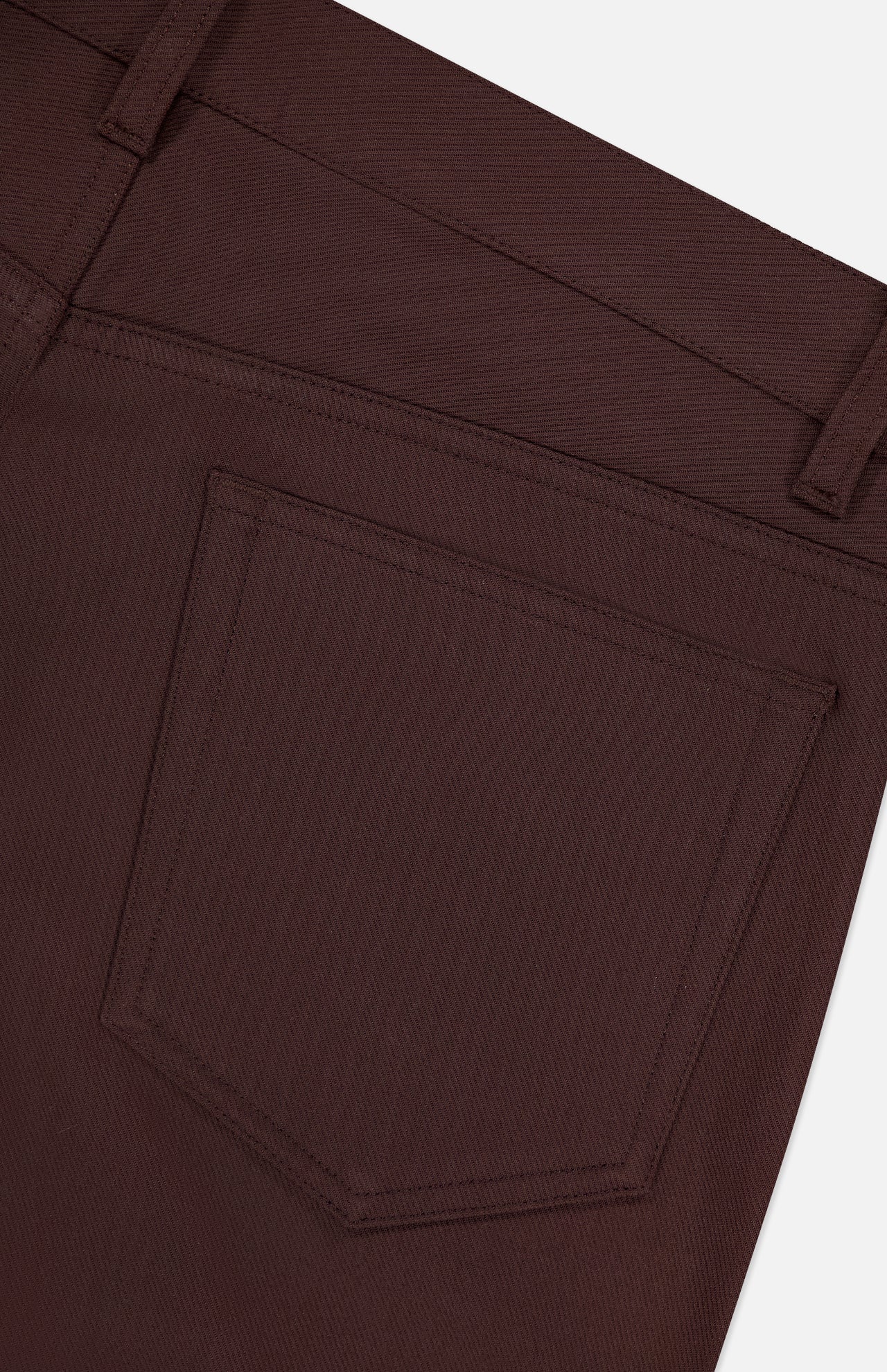 Close-up of the back pocket on THEORY’s Raffi Stretch Twill Pants in slim fit dark brown, highlighting detailed stitching, waistband, and belt loop. The sturdy twill fabric offers a smooth feel and comfortable 4-way stretch.