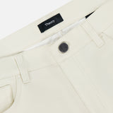 Close-up of the waistband on Raffi Stretch Twill Pants in an oat milk tone, featuring a black button, belt loops, front pocket, and a black THEORY label sewn inside.