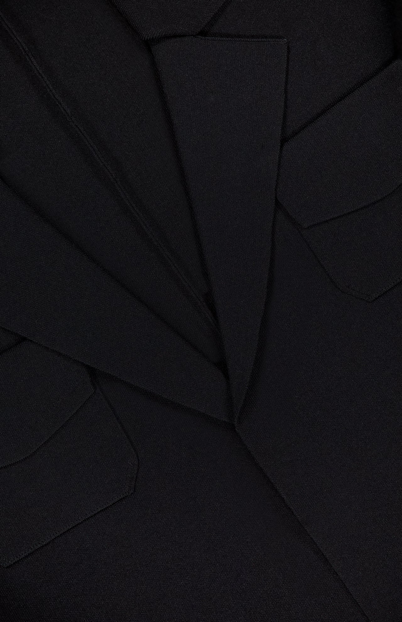 Close-up of the THEORY Relaxed Belted Blazer in black, featuring a textured fabric, lapels, collar, and two flap front pockets—a perfect choice for polished office outfits.