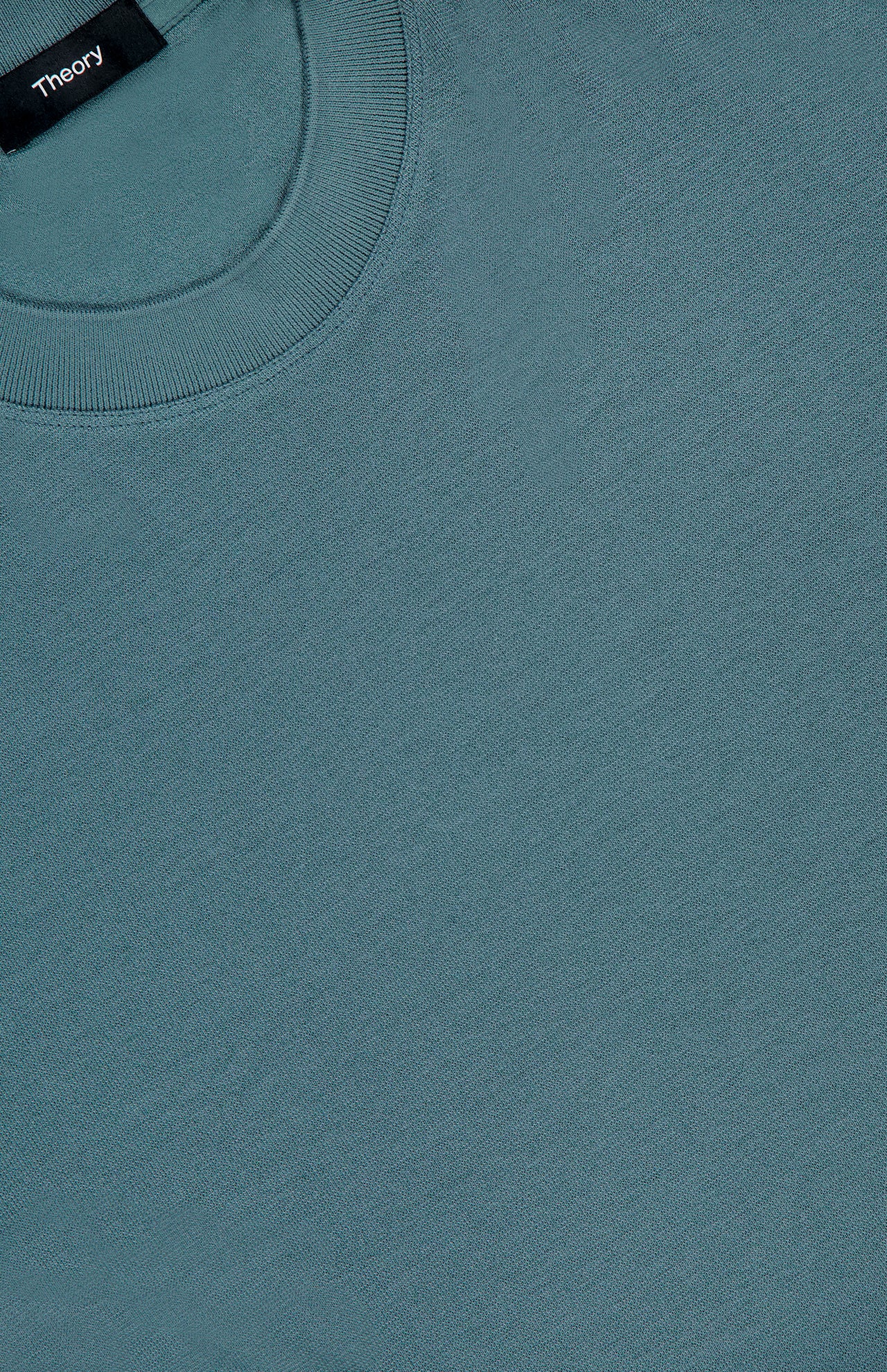 A close-up of the Sarior Stretch T-shirt by THEORY shows the inside collar label, highlighting its stretch jersey fabric and precise stitching.
