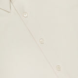 Close-up of THEORY’s Sylvain Slim Structure Shirt in a cream hue, showcasing its wrinkle-resistant fabric, slim fit collar, smooth texture, and button details.