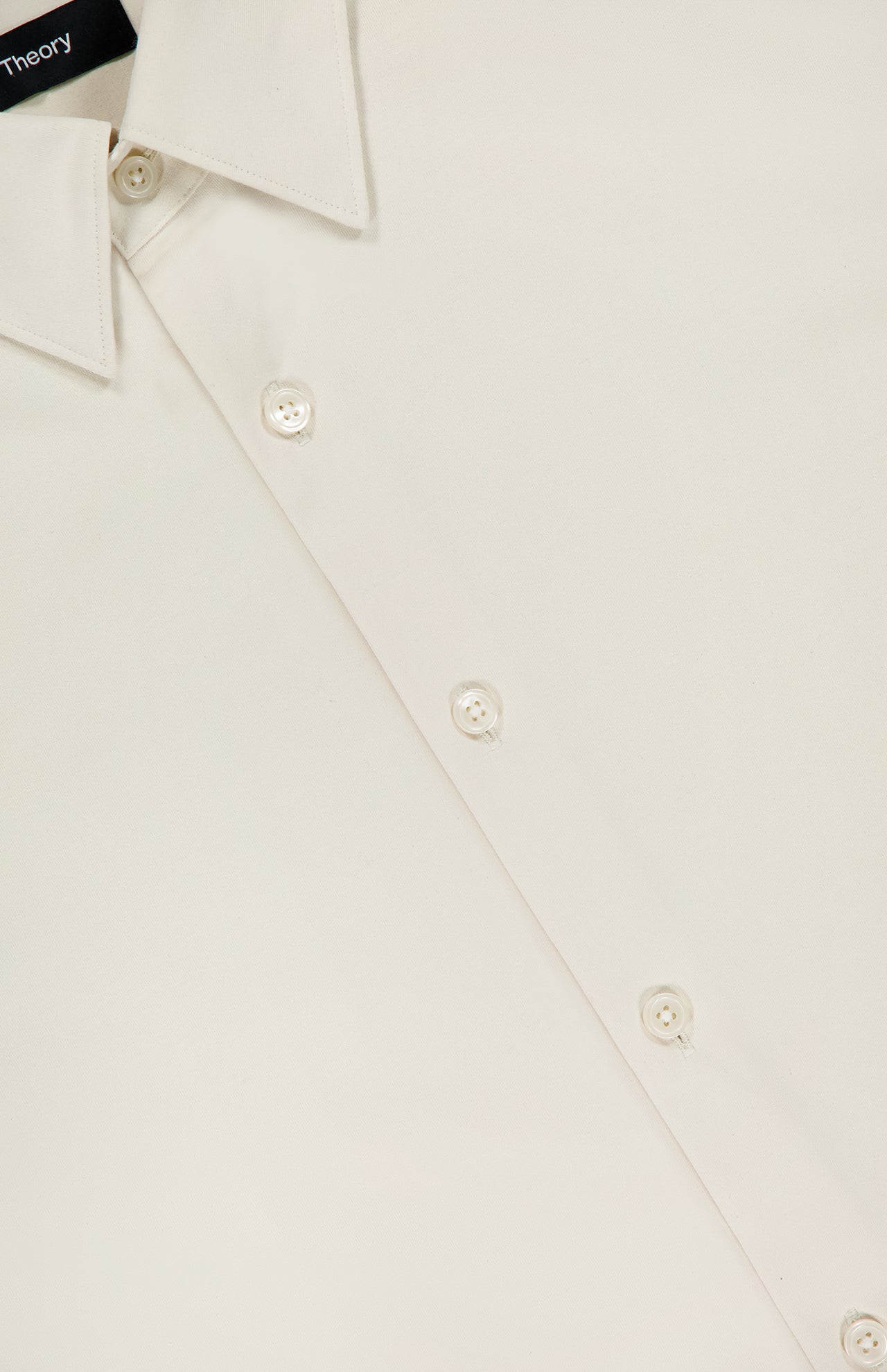 Close-up of THEORY’s Sylvain Slim Structure Shirt in a cream hue, showcasing its wrinkle-resistant fabric, slim fit collar, smooth texture, and button details.