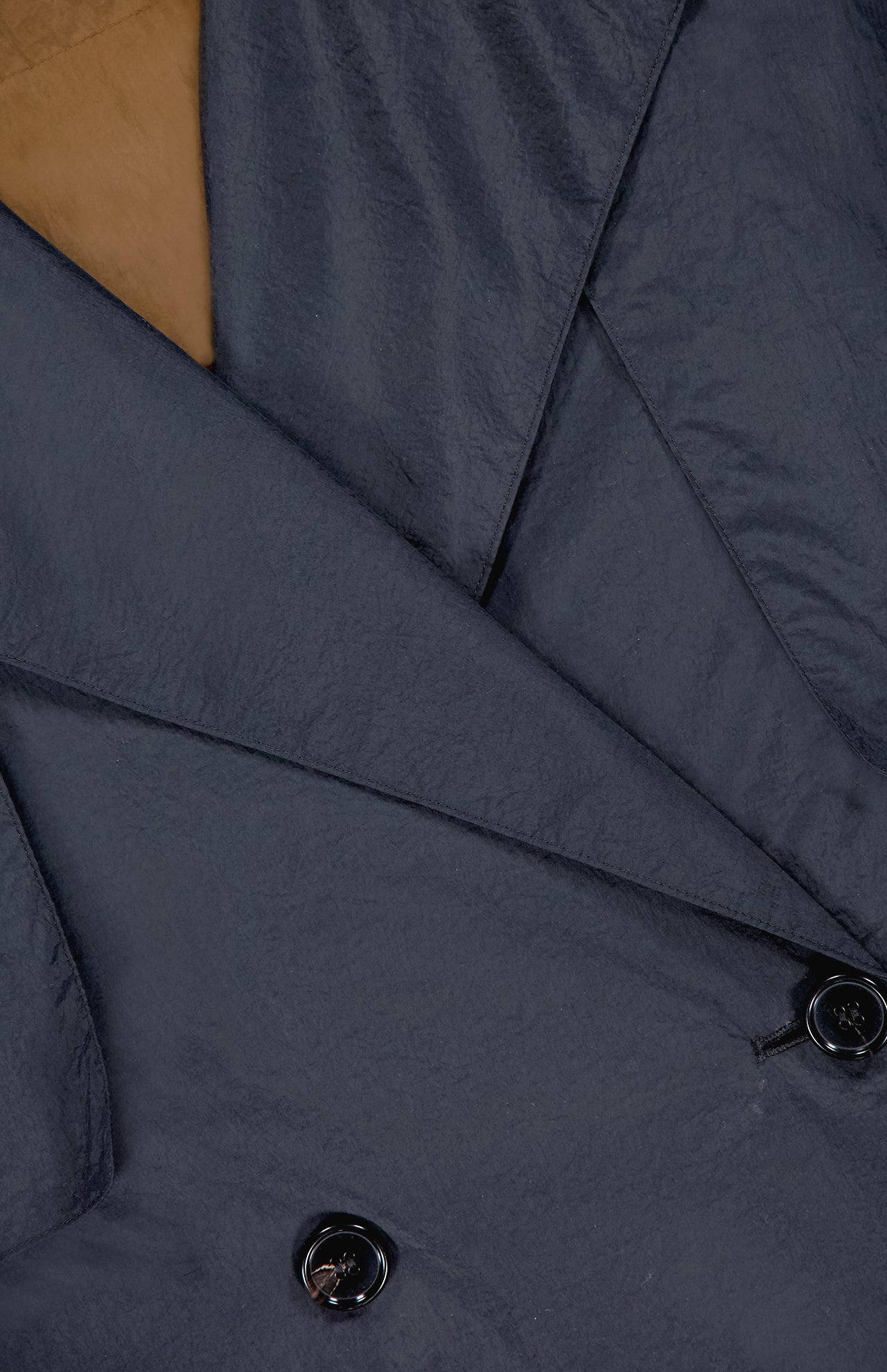 Close-up of the THEORY Airy Nylon Trench Coat in dark gray, double-breasted with shiny black buttons and textured fabric—sleek lapel details make it a perfect capsule wardrobe essential.