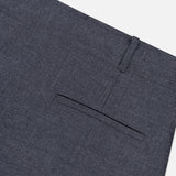 Close-up of the back pocket and waistband of the THEORY Aline Pleated Mini Skirt in dark gray wool-blend, shown against a white background. The skirt features a welt-style back pocket and a visible belt loop above it.