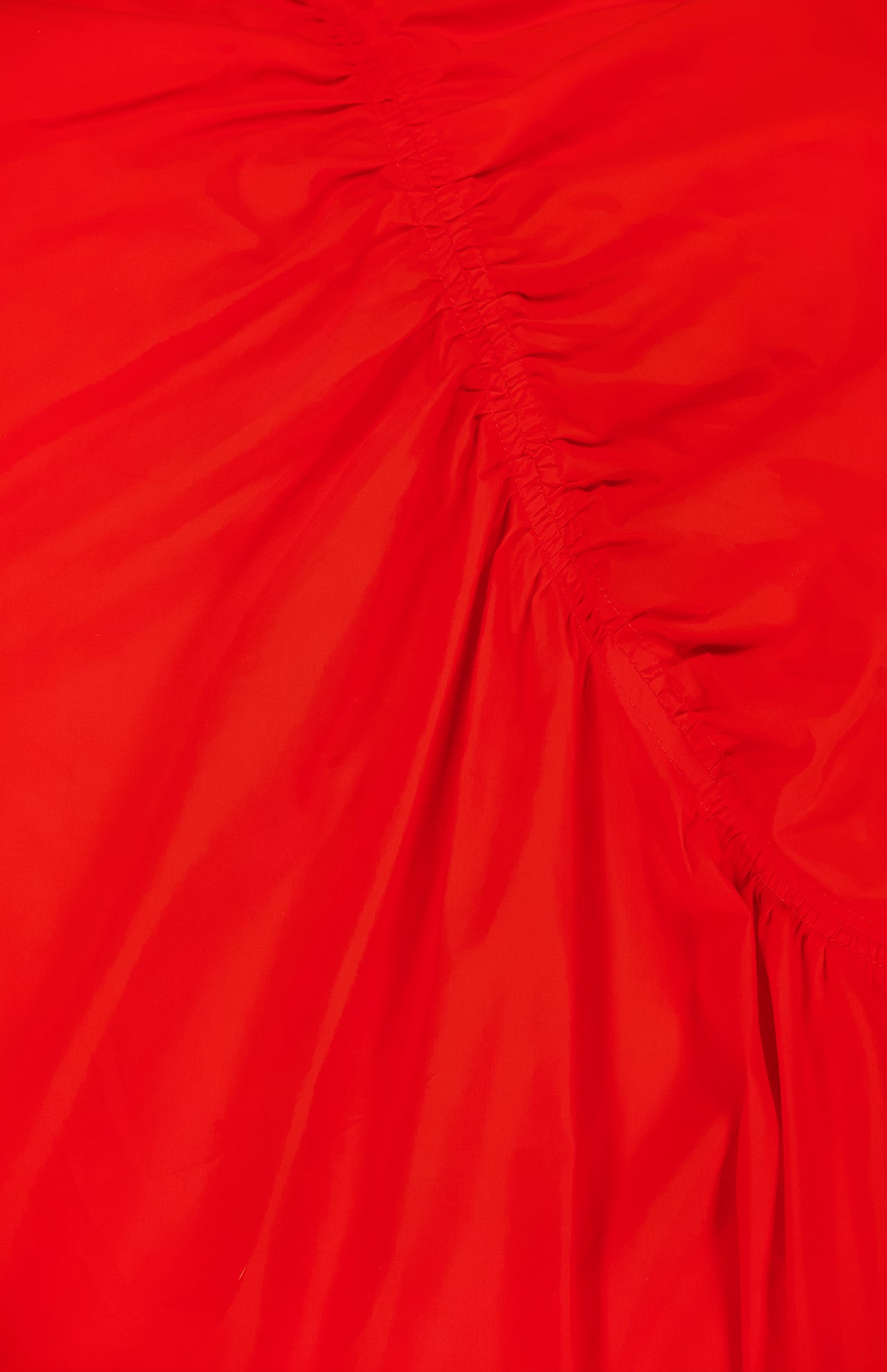 A close-up of the THEORY Asymmetrical Ruched Tank Dress in bright red shows gathered, diagonal ruching that creates textured folds—an elegant detail, perfect for casual wear.
