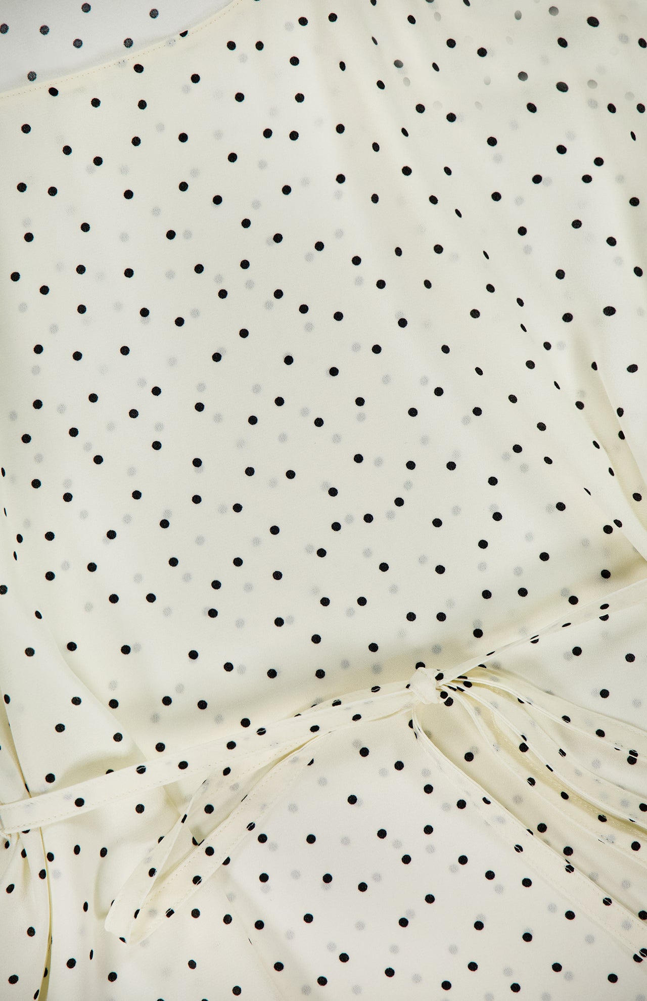 The THEORY Polka Dot Belted Scoop Neck Top features chic cream fabric with small black polka dots and a slim, matching belt, making it a stylish sleeveless blouse ideal for office wear.
