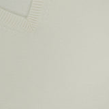 Close-up of the Cashmere Cropped V-Neck T-Shirt in ivory, featuring a cream-colored ribbed V-neck collar. A black THEORY brand tag with size S is visible at the neckline.