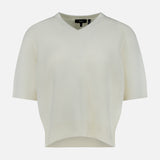 The THEORY Cashmere Cropped V-Neck T-Shirt is a short-sleeved, cream-colored knit sweater featuring a slightly cropped t-shirt silhouette and a V-neck, shown against a plain white background.