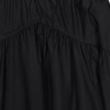 Close-up of the THEORY Curved Yoke Circle Skirt in black, crafted from lightweight, slightly shiny fabric with a pull-on elastic waistband and gathered detail below a curved seam.