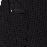 Close-up of THEORY’s Easy Eyelet Slim Fit Pant in black embroidered eyelet cotton with circular cutouts, shown partially unzipped to reveal the waistband, button, and lining. The slim fit style is displayed flat.