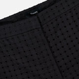 Close-up of Easy Eyelet Slim Fit Pant in black embroidered eyelet cotton, featuring a visible seam and a black THEORY label.