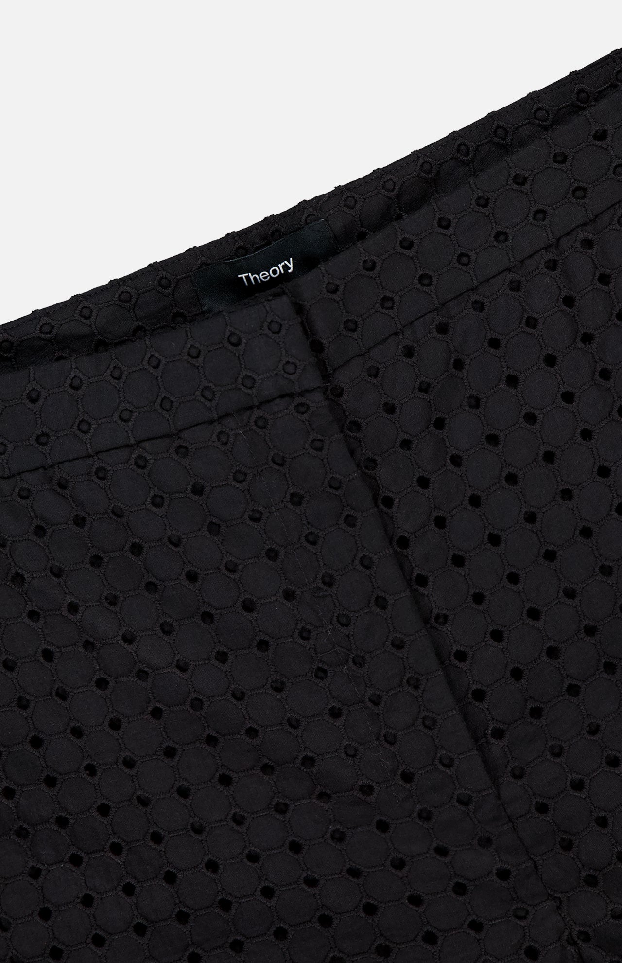 Close-up of Easy Eyelet Slim Fit Pant in black embroidered eyelet cotton, featuring a visible seam and a black THEORY label.