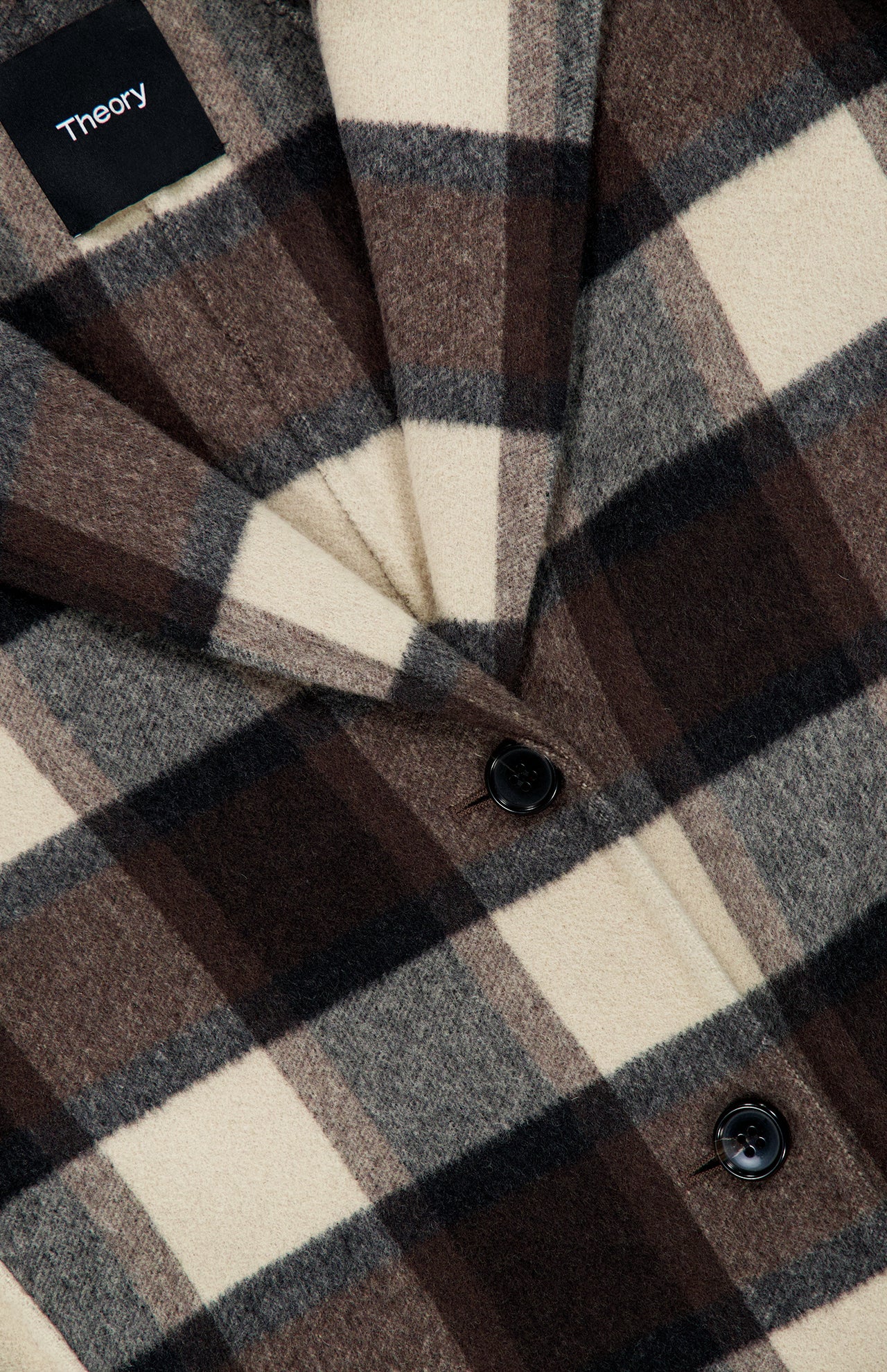 A close-up of a brown, black, and cream Elongated Plaid Blazer Coat by Theory, featuring a notched lapel and black buttons.
