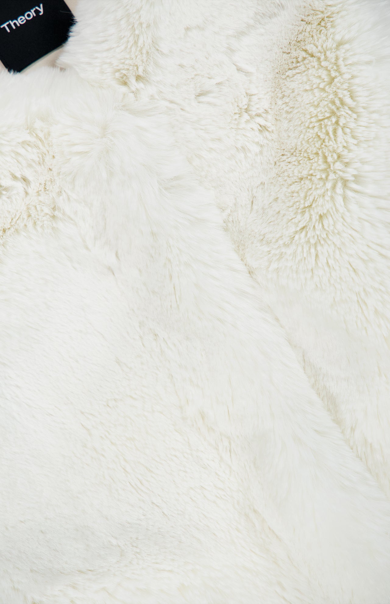 Close-up of the ivory faux fur texture on a Theory Faux Fur Gilet zip-front vest.