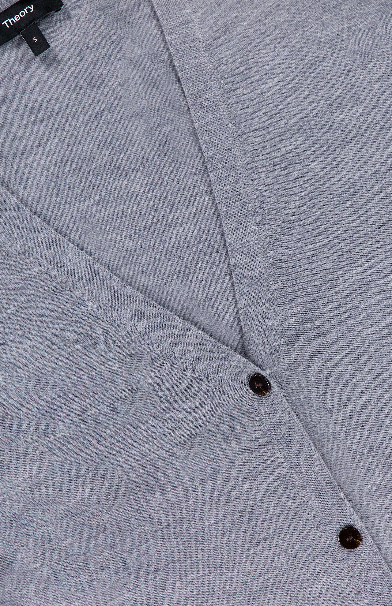 Close-up of the THEORY Long Merino Wool Cardigan in light grey, featuring a V-neckline, two dark buttons, and a visible black label in the top left corner.