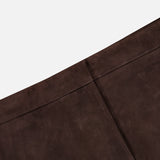 Close-up of THEORY’s Lamb Leather Mini Trouser Skirt in rich chocolate brown, crafted from soft lamb leather with a seam and visible stitching, photographed at an angle against a white background.