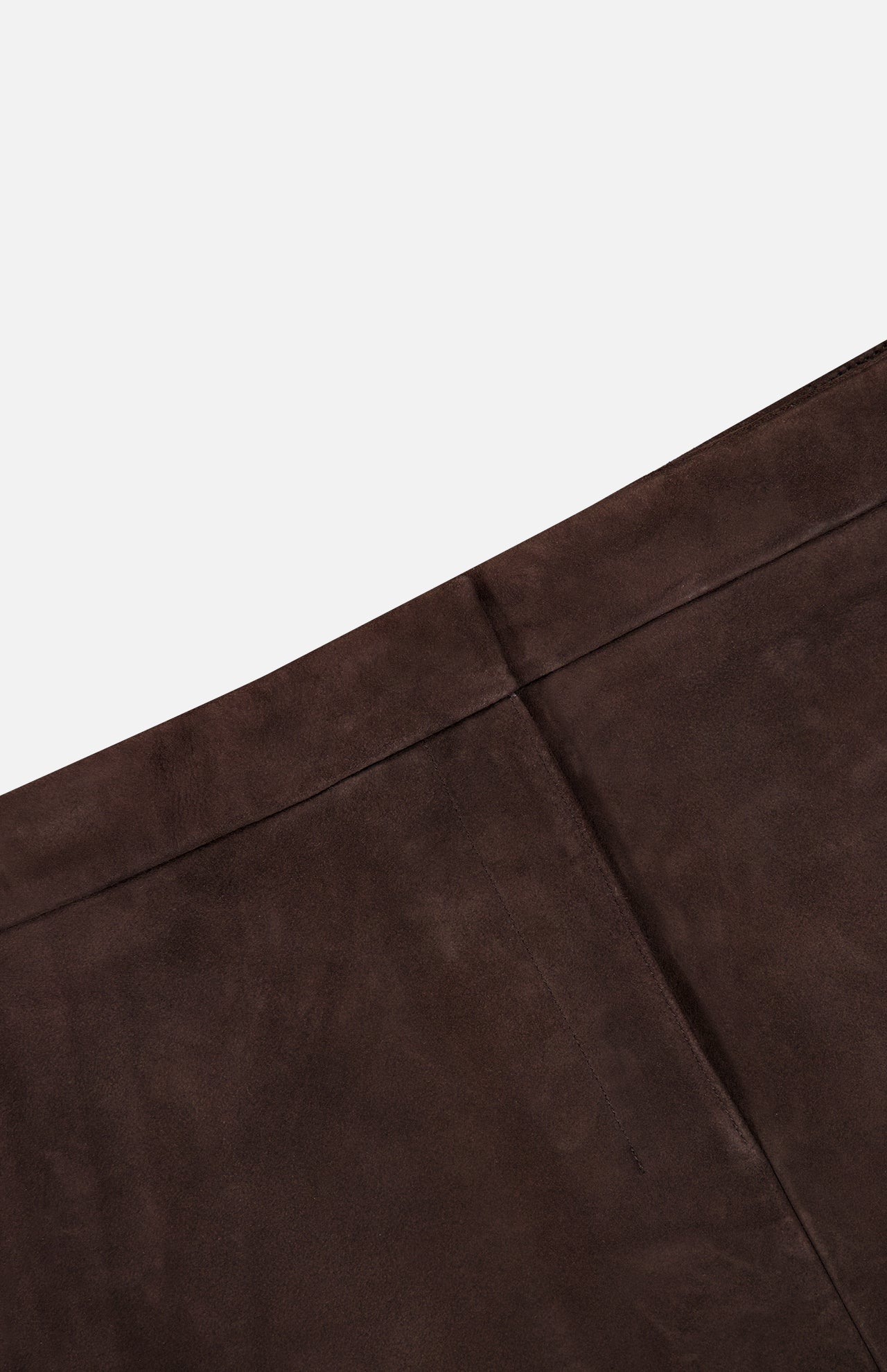 Close-up of THEORY’s Lamb Leather Mini Trouser Skirt in rich chocolate brown, crafted from soft lamb leather with a seam and visible stitching, photographed at an angle against a white background.