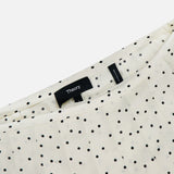 Close-up of the Pleated Polka Dot Wrap Skirt by THEORY, featuring a stylish pleated design and bold black polka dots—a chic piece for a polished office look.