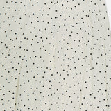 Close-up of the THEORY Pleated Polka Dot Wrap Skirt, featuring white fabric with evenly spaced small black polka dots—ideal for office wear or chic, versatile styling.